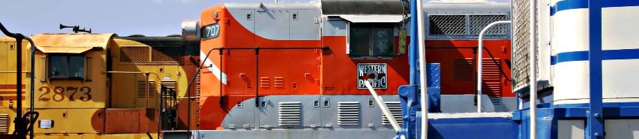 side by side yellow orange blue freight trains